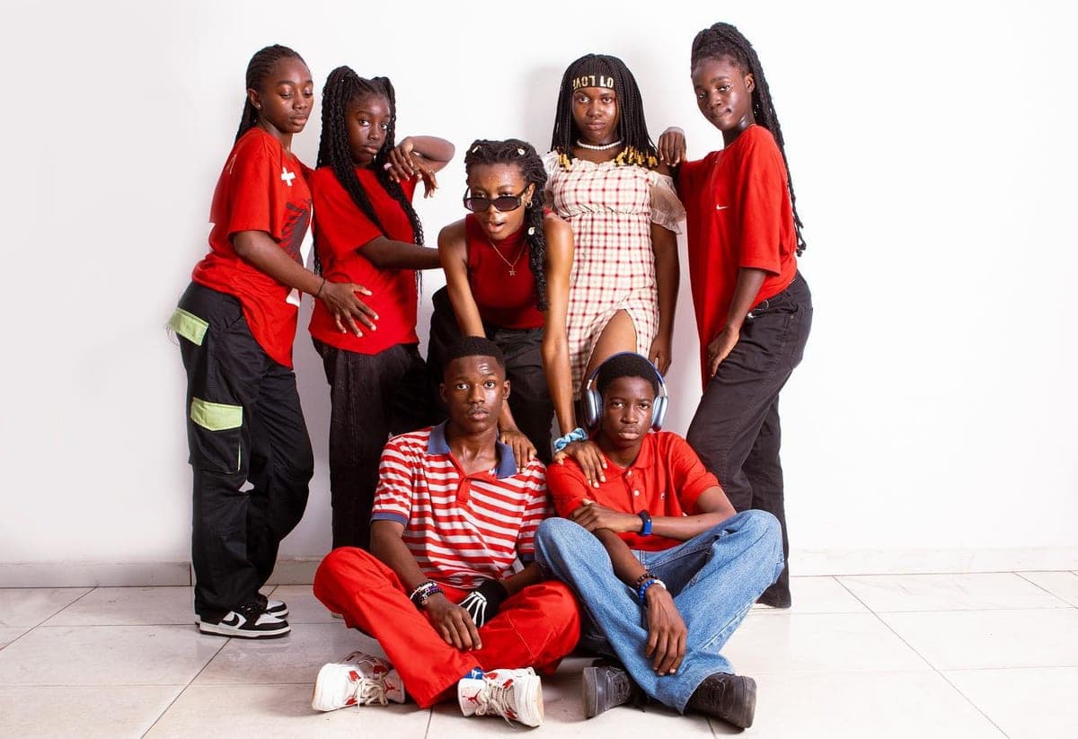 Un groupe de danseurs en tenue rouge, en studio.